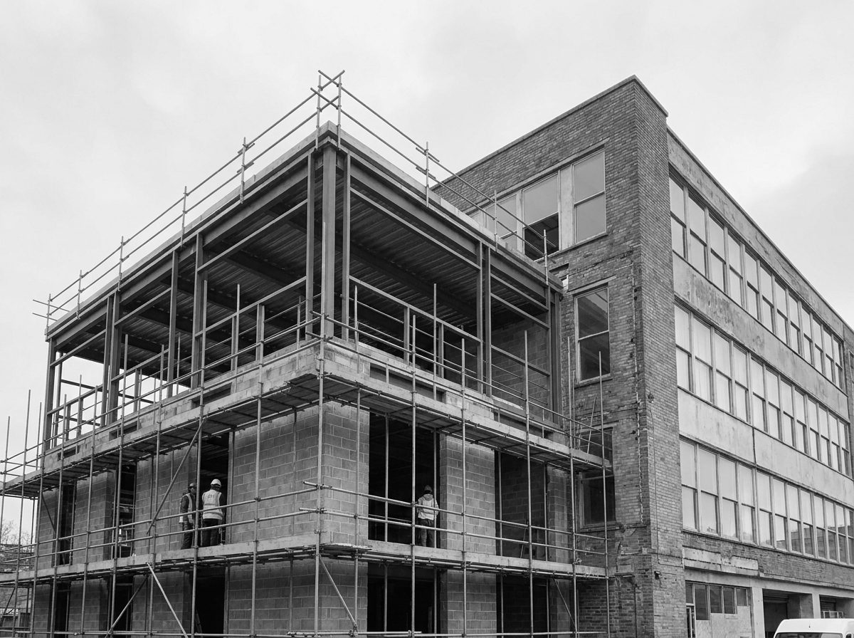 Uitbreiding van een bedrijfspand in aanbouw, nieuwe ruwbouw tegen het bestaande pand