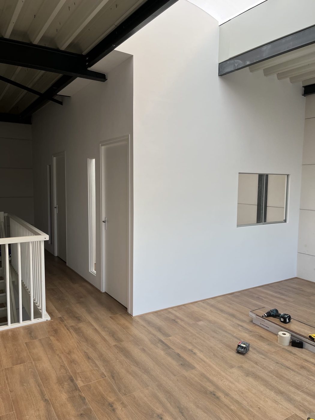 De afgewerkte ruimte: gestucte witte wanden, nieuwe deuren en een houten vloer