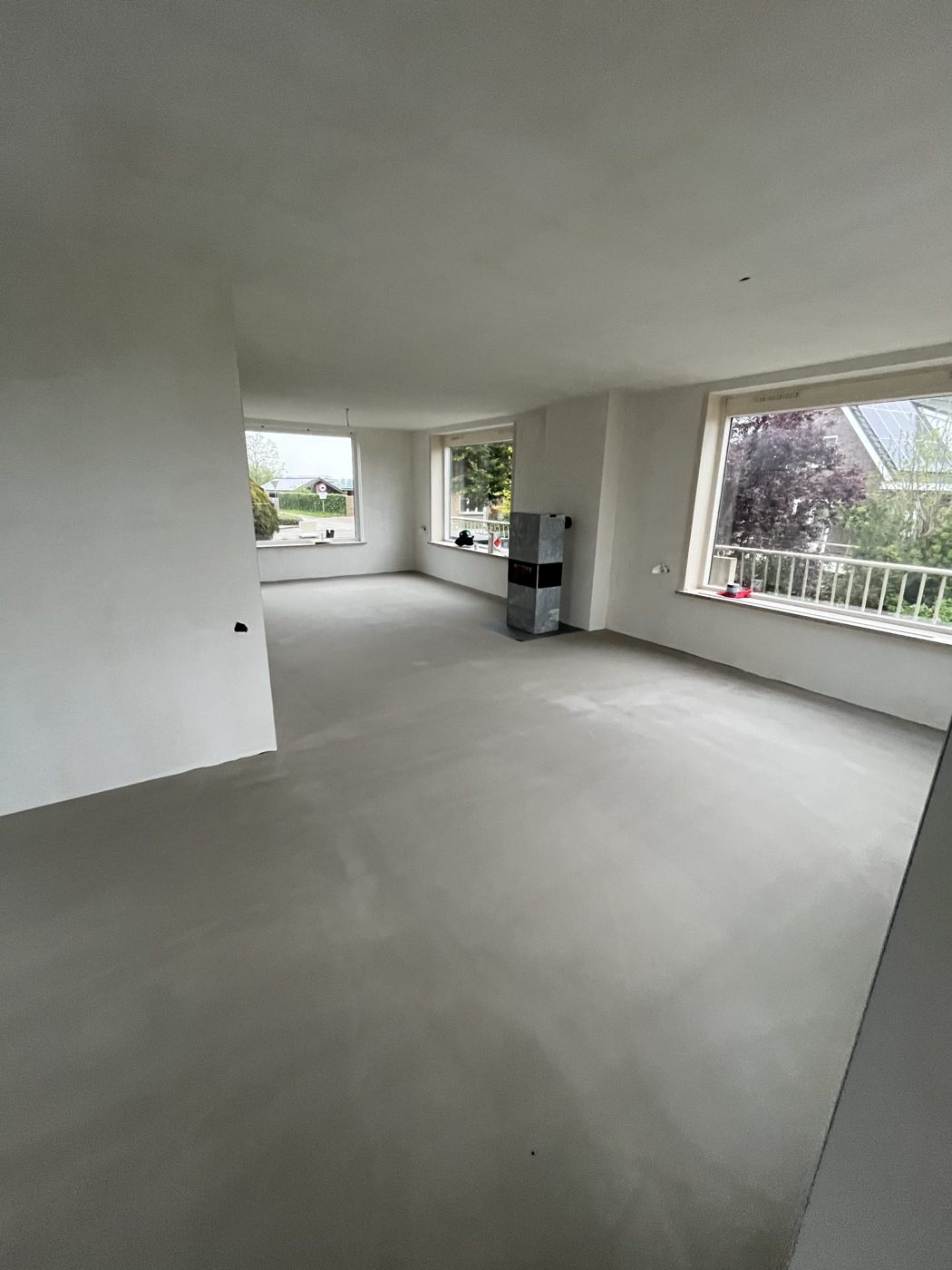 De gerenoveerde woonkamer: gladde gestucte wanden en plafond en een egale vloer